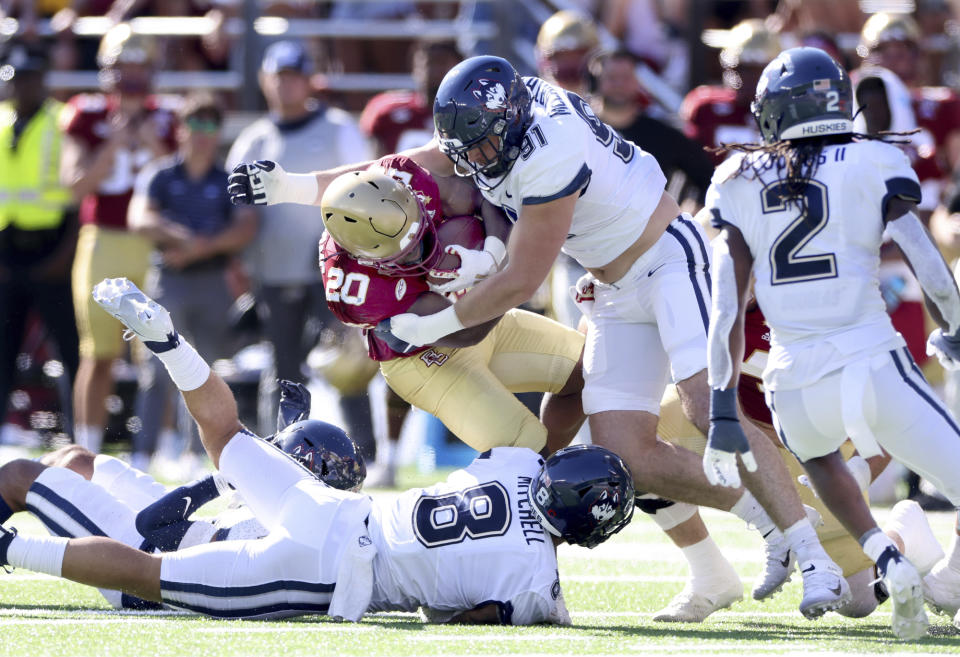 Boston College Eagles running back Alex Broome (20) gets tackled by UConn defense including Colin McCarthy (91) during the first half of an NCAA college football game Saturday, Oct. 28, 2023 in Boston. (AP Photo/Mark Stockwell)