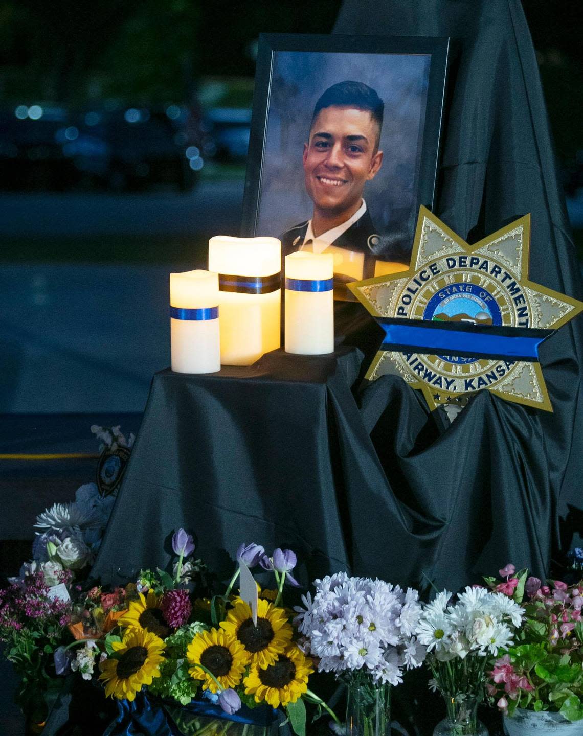 A photo of fallen Fairway police officer Jonah Oswald was displayed Saturday at a vigil at Harmon Park, 7700 Mission Road, in Prairie Village.