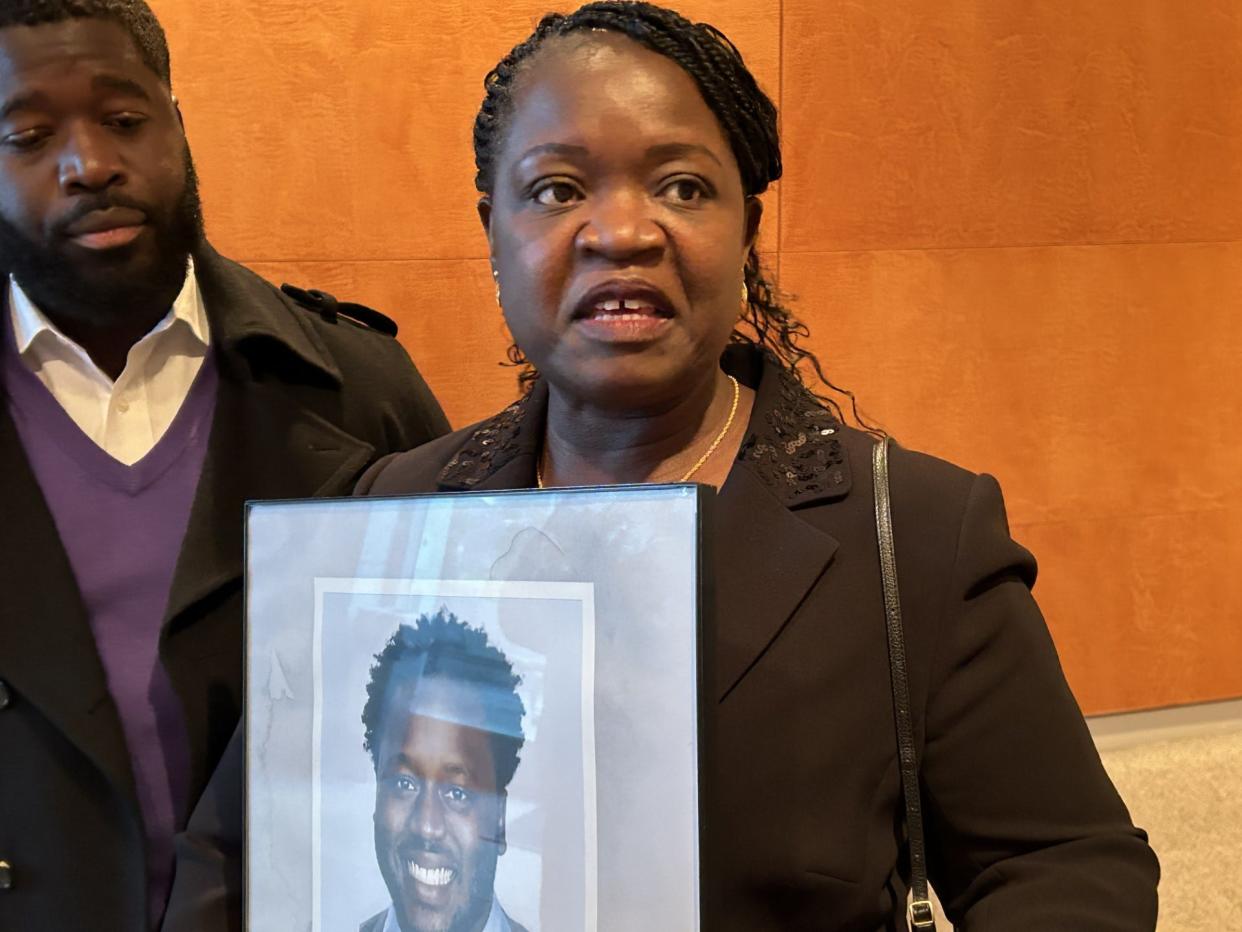 Caroline Ouko, mother of Irvo Noel Otieno, holds a photo of her son as she meets with reporters following an event Thursday, Dec. 14, 2023, at the Library of Virginia in Richmond. Gov. Glenn Youngkin announced at the event that he would propose 'Irvo's Law' to the 2024 Virginia General Assembly that would allow family members unfettered access to their loved ones undergoing mental crisis at a hospital or hospital emergency room.