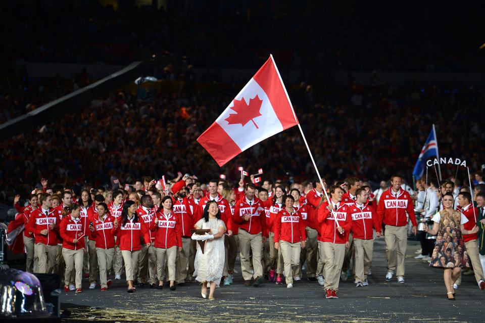 LONDON, ENGLAND - JULY 27: Simon Whitfield of the Canada Olympic triathlon team carries his country's flag during the Opening Ceremony of the London 2012 Olympic Games at the Olympic Stadium on July 27, 2012 in London, England. (Photo by Lars Baron/Getty Images)