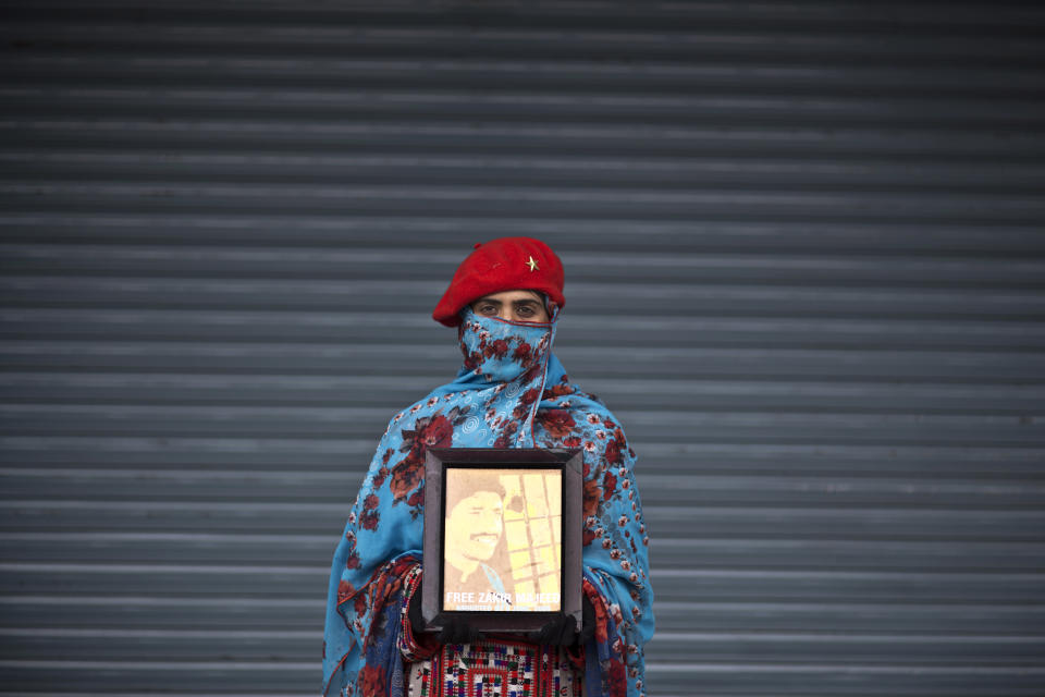 Farzana Majeed, 27, poses for a portrait holding a photograph of her brother Zakir, who went missing on June 8, 2009, while she and other relatives take a break from a long march protest, in Rawalpindi, Pakistan, Friday, Feb. 28, 2014. Farzana is one of two dozen activists from the impoverished southwestern province of Baluchistan who walked roughly 3,000 kilometers (1,860 miles) to the capital of Islamabad to draw attention to alleged abductions of their loved ones by the Pakistani government.(AP Photo/Muhammed Muheisen)