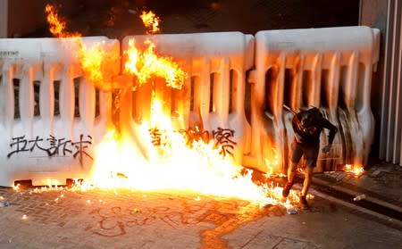 A demonstrator runs away from a burning barricade during a protest in Hong Kong