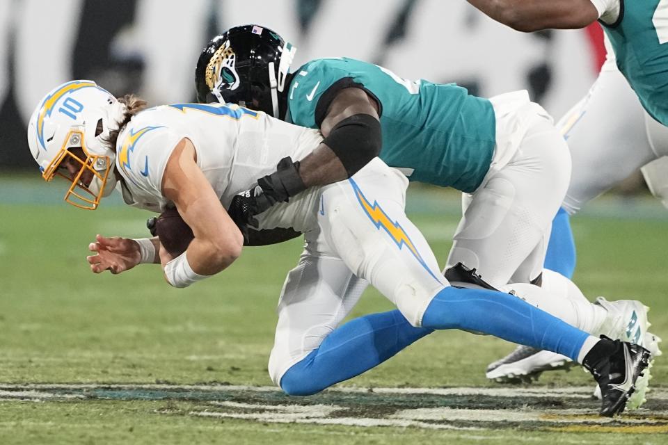 Jacksonville Jaguars linebacker Josh Allen (41) hits Los Angeles Chargers quarterback Justin Herbert (10) during the first half of an NFL wild-card football game, Saturday, Jan. 14, 2023, in Jacksonville, Fla. (AP Photo/Chris Carlson)