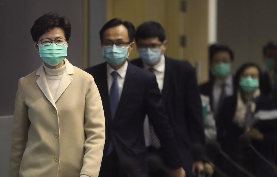 Hong Kong Chief Executive Carrie Lam, front, and other government officials wear protective face masks before a press conference in Hong Kong, Friday, Jan. 31, 2020. China has moved to lock down at least three big cities in an unprecedented effort to contain the deadly new virus that has sickened hundreds of people and spread to other parts of the world. (AP Photo/Achmad Ibrahim)