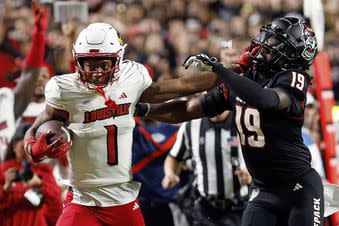 Louisville's Jamari Thrash (1) stiff-arms North Carolina State's Bishop Fitzgerald (19) during the second half of an NCAA college football game in Raleigh, N.C., Friday, Sept. 29, 2023. (AP Photo/Karl B DeBlaker)