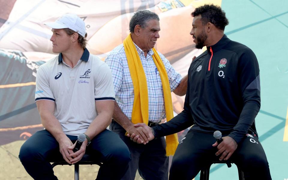 Mark Ella (centre) shakes hands with England Captain Courtney Lawes (right) ahead of the opening Test of the three-match series between Australia and England - AFP