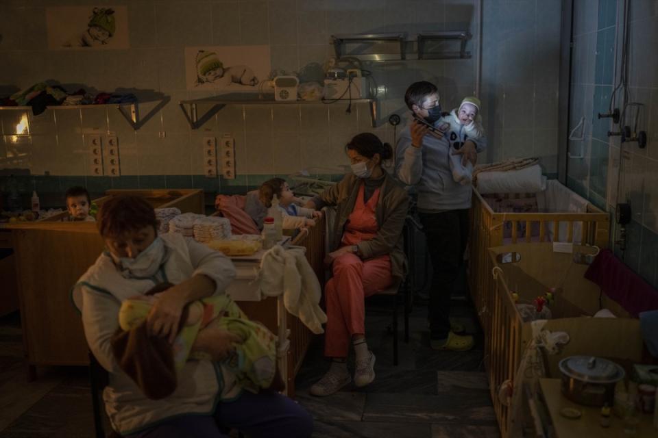 2022年11月22日，烏克蘭赫爾松，數名醫院員工在停了電的醫院嬰兒病房內照顧幼嬰。