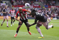 Brentford's Bryan Mbeumo, left, and Fulham's Calvin Bassey battle for the ball during the English Premier League soccer match between Fulham FC and Brentford FC at the Gtech Community Stadium in London, Saturday May 4, 2024. (John Walton/PA via AP)