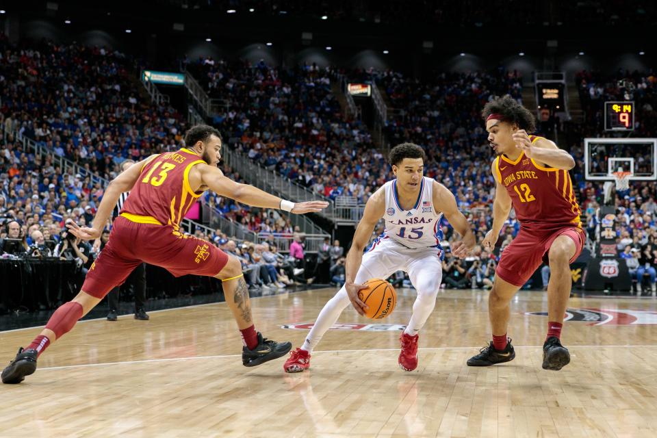 Kansas guard Kevin McCullar Jr. (15) drives between Iowa State guard Jaren Holmes (13) and Iowa State forward Robert Jones (12) during the first half Friday of a Big 12 Conference tournament game in Kansas City at the T-Mobile Center.