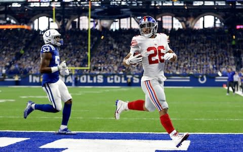 New York Giants running back Saquon Barkley (26) runs in for a touchdown in front of Indianapolis Colts outside linebacker Darius Leonard (53) during the first half of an NFL football game in Indianapolis. The betting favorite for NFL Offensive Rookie of the Year is Barkley - Credit: AP