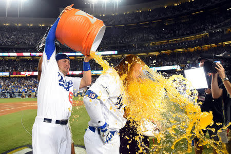 Oct 15, 2017; Los Angeles, CA, USA; Los Angeles Dodgers third baseman Kyle Farmer (65) dumps gatorade on third baseman Justin Turner (10) after he hit the game winning walk off home run in the ninth inning against the Chicago Cubs in game two of the 2017 NLCS playoff baseball series at Dodger Stadium. Mandatory Credit: Jayne Kamin-Oncea-USA TODAY Sports