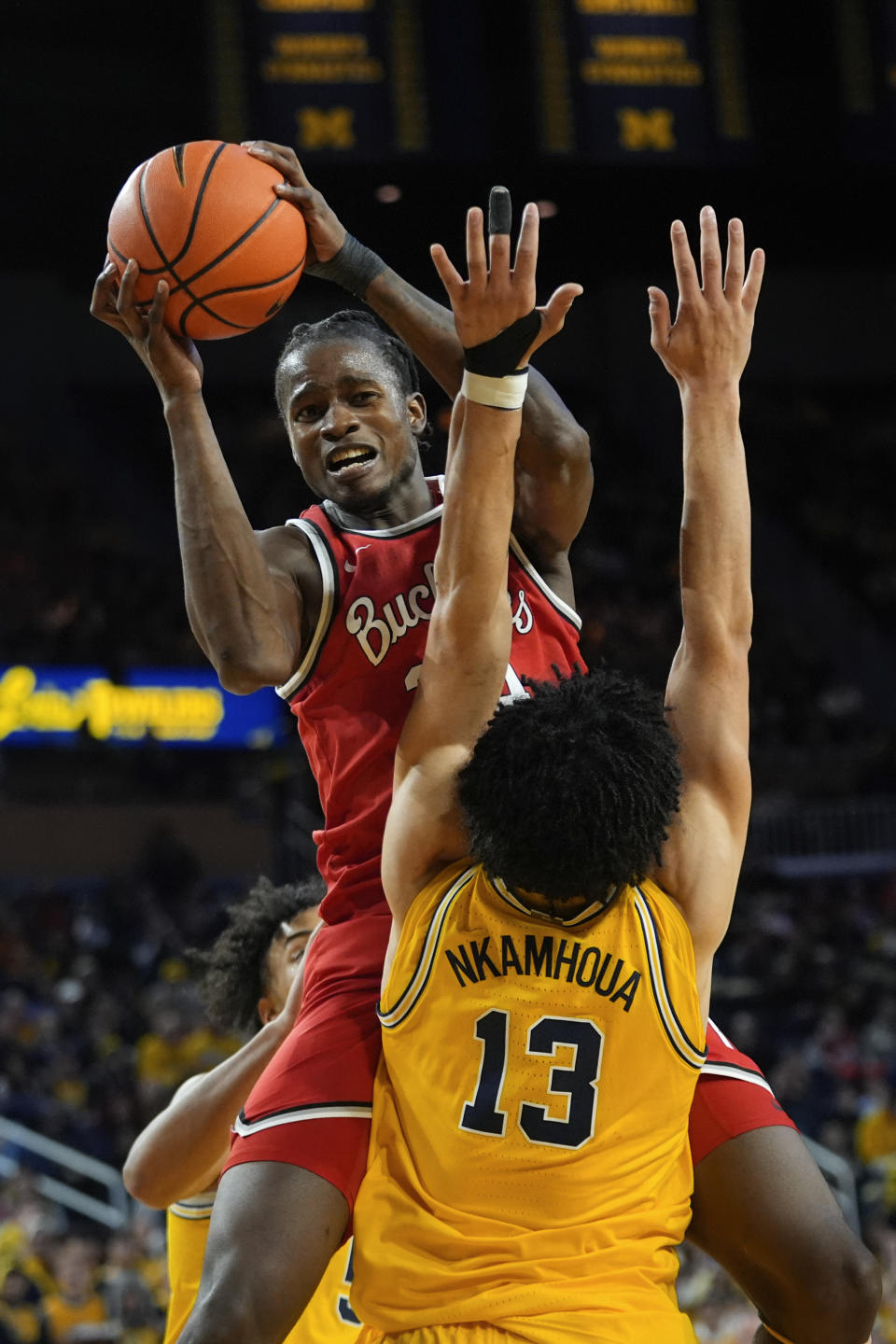 Ohio State center Felix Okpara (34) drives on Michigan forward Olivier Nkamhoua (13) in the first half of an NCAA college basketball game in Ann Arbor, Mich., Monday, Jan. 15, 2024. (AP Photo/Paul Sancya)