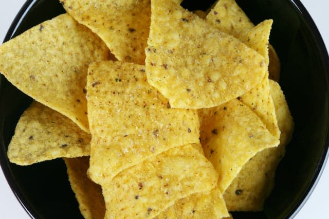 Portion of Tortilla Corn Chips Snack Served in Black Bowl