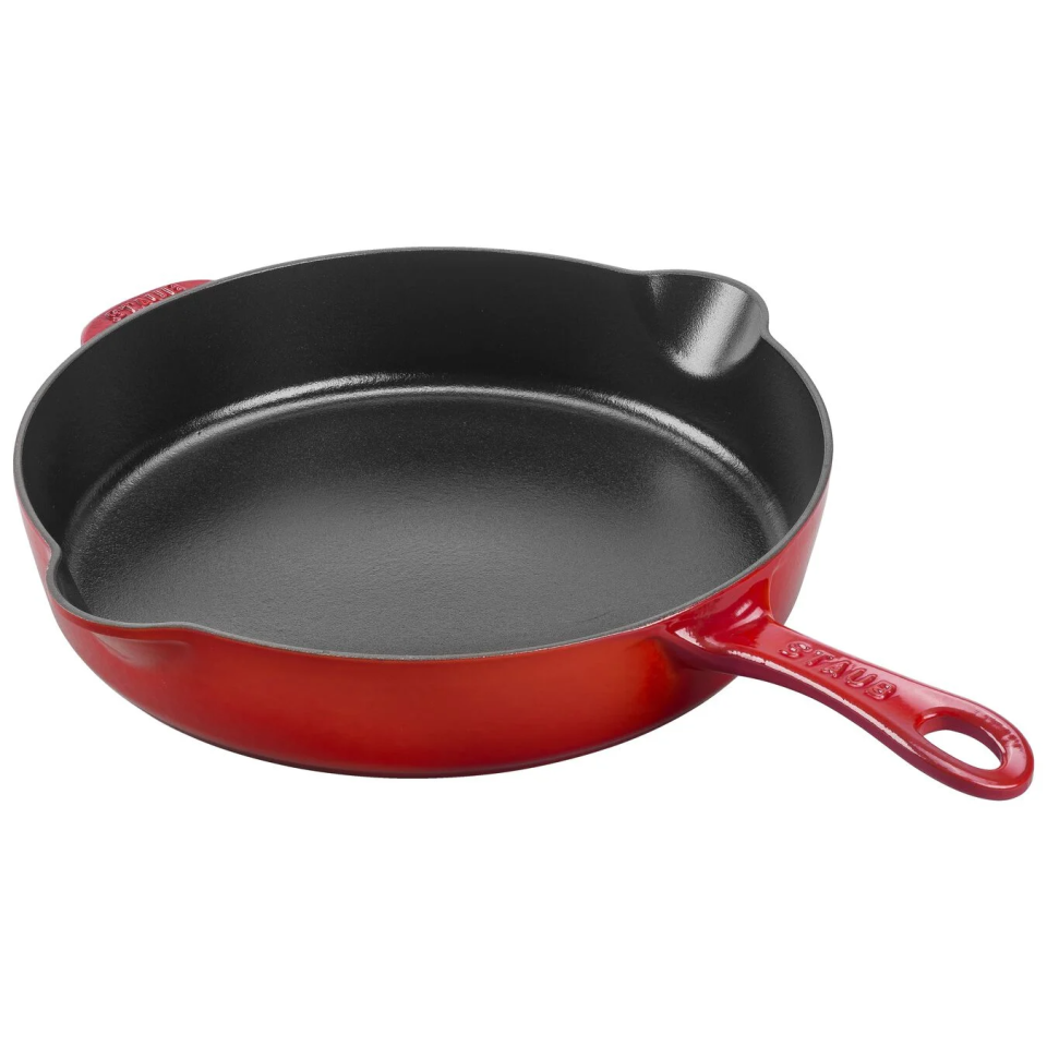 red and black cast iron skillet on white background