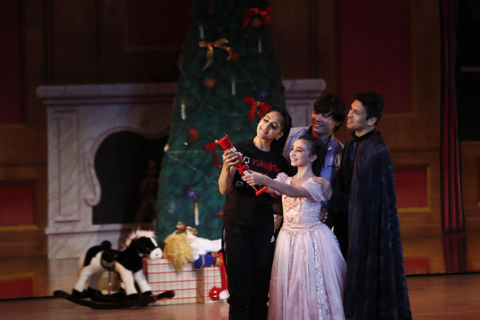 Dancer Lusian Hernandez, left, who portrays Mrs. Stahlbaum, Haowei Zhu, as Mr. Stahlbaum, left back, Sophia Torrens, as Clara, center, and Pablo Manzo, as Fritz, right, act during a rehearsal of Vladimir Issaev's rendition of The Nutcracker ballet on Friday, Dec. 13, 2019, in Fort Lauderdale, Fla. More than 20 dancers of Venezuelan origin were playing various roles on a recent performance of the holiday favorite “The Nutcracker.” Some of these dancers are here seeking asylum after fleeing their crisis-torn nation, which is plagued by shortages of food and medicine. (AP Photo/Brynn Anderson)