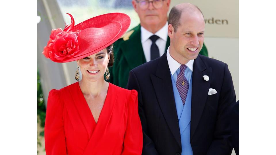 Kate Middleton in a red outfit and Prince William in a black suit