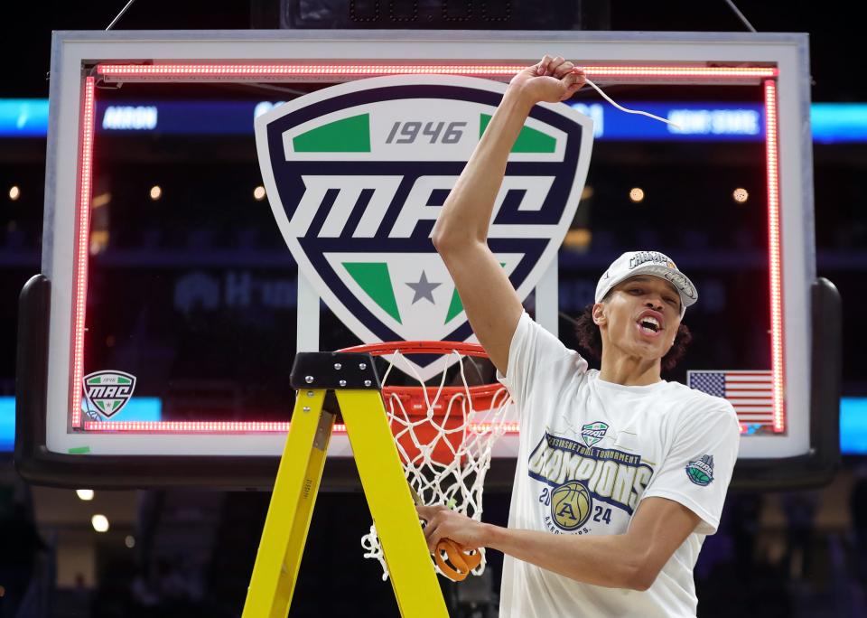 Akron's Enrique Freeman (25) whips the first piece of the net after the Zips defeated Kent State in the Mid-American Conference Tournament championship game Saturday in Cleveland.