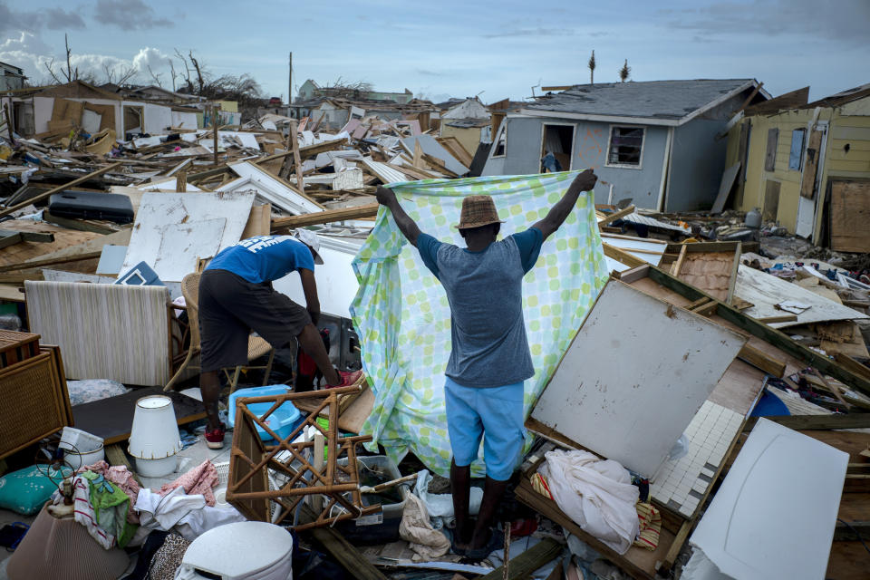 Immigrants from Haiti recover their belongings from the rubble in their destroyed homes, in the aftermath of Hurricane Dorian in Abaco, Bahamas, Monday, Sept. 16, 2019. Dorian hit the northern Bahamas on Sept. 1, with sustained winds of 185 mph (295 kph), unleashing flooding that reached up to 25 feet (8 meters) in some areas. (AP Photo/Ramon Espinosa)