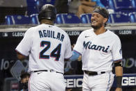 Miami Marlins' Miguel Rojas, right, and Jesus Aguilar (24) congratulate each other after scoring during the fifth inning of a baseball game against the Baltimore Orioles, Wednesday, April 21, 2021, in Miami. (AP Photo/Marta Lavandier)