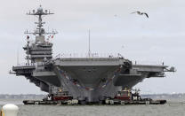 The nuclear aircraft carrier Harry S. Truman approaches the pier at Naval Station Norfolk in Norfolk, Va., Friday, April 18, 2014. The Carrier Strike Group is returning form a 9-month deployment to the Middle East. (AP Photo/Steve Helber)