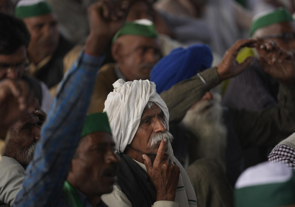 Farmers listen to their leaders during a rally at Ghazipur, on the outskirts of New Delhi, India, Friday, Nov. 26, 2021. Tens of thousands of farmers rallied on Friday marking one year of their movement that forced Prime Minister Narendra Modi to withdraw three agriculture laws that feared would drastically reduce their incomes and leave them at the mercy of corporations. (AP Photo/Manish Swarup)