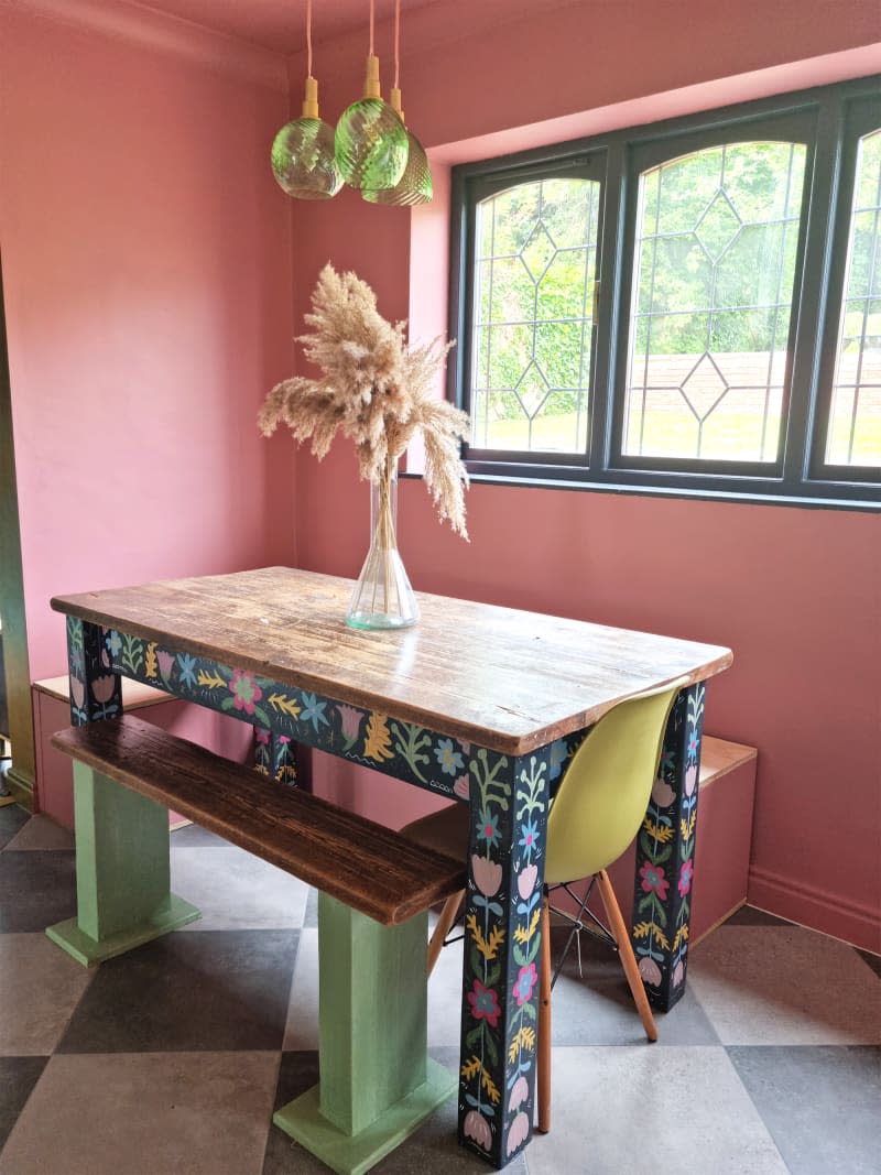 The dining table frame in the newly renovated home is brightly painted.