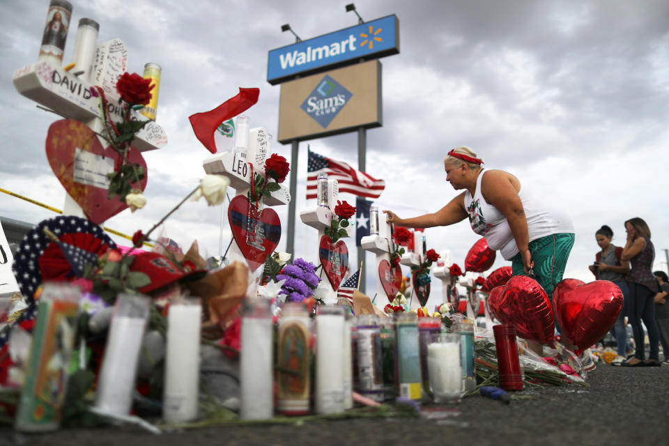 A woman touches a cross at a makeshift memorial for victims outside Walmart, near the scene of a mass shooting which left at least 22 people dead, on August 6, 2019 in El Paso, Texas. A 21-year-old white male suspect remains in custody in El Paso, which sits along the U.S.-Mexico border. President Donald Trump plans to visit the city August 7. (Mario Tama / Getty Images file)