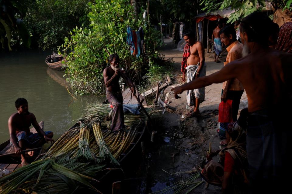 Villagers bargain with a seller to purchase sugarcane (Reuters)