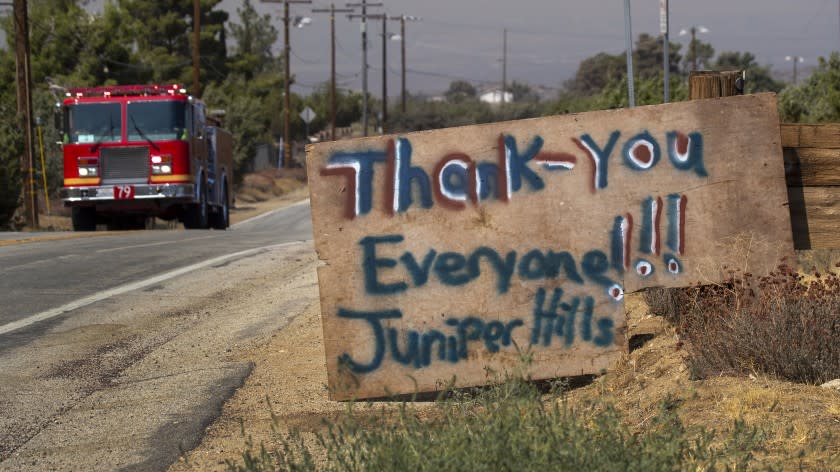 JUNIPER HILLS, CA - SEPTEMBER 20: A thank-you sign posted by thankful residents is posted as a firetruck races by as the Bobcat fire continues to burn in the Angeles National Forest in Juniper Hills Sunday, Sept. 20, 2020. Some houses and structures in the Juniper Hills area were lost in the Bobcat fire but most were saved. (Allen J. Schaben / Los Angeles Times)