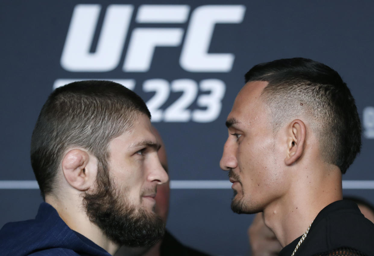 Khabib Nurmagomedov, left, poses for photographers with UFC featherweight champion Max Holloway, Thursday, April 5, 2018, during UFC223's media day at the Barclays Center in New York, ahead of their lightweight championship bout Saturday, April 7th, at the Brooklyn arena. (AP Photo/Kathy Willens)