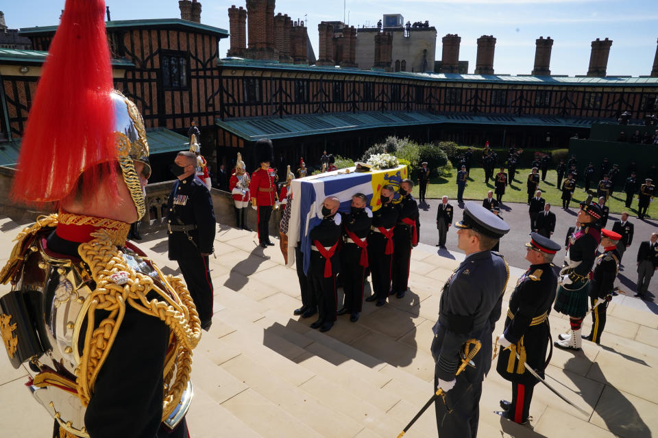 The coffin is held on the steps of St George's Chapel during the procession of Britain Prince Philip's funeral at Windsor Castle, Windsor, England, Saturday April 17, 2021. Prince Philip died April 9 at the age of 99 after 73 years of marriage to Britain's Queen Elizabeth II. (Arthur Edwards/Pool via AP)