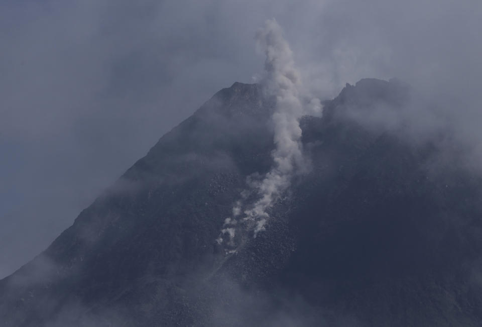 Mount Merapi spews volcanic materials from its crater as seen from Sleman, Yogyakarta, Indonesia, Thursday, Jan. 7, 2021. The 2,968-meter (9,737-foot) mountain spewed avalanches of hot clouds on Thursday morning amid its increasing volcanic activities. (AP Photo/Taufiq Rozzaq)