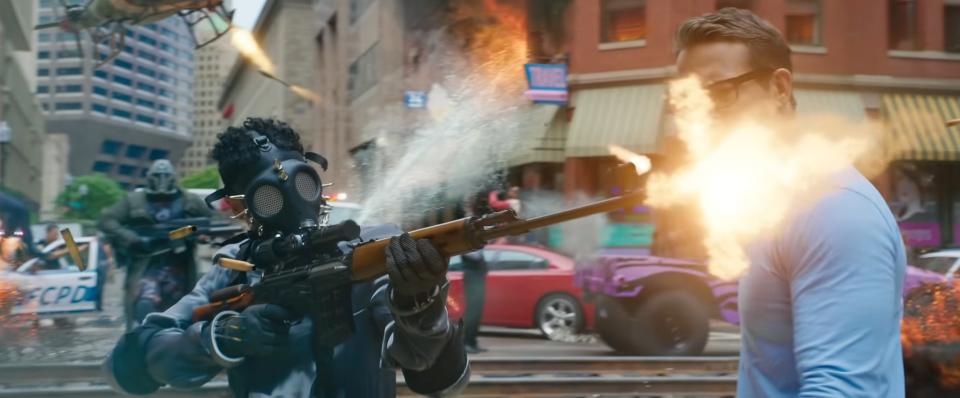 A man wearing a gas mask shooting a rifle