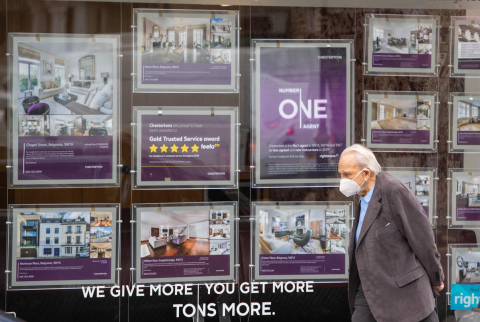 A man wearing a protective face mask passes an estate agents window in Knightsbridge, London, as annual house price growth ground to a halt in June, with property values down by 0.1% year on year, according to Nationwide building society. (Photo by Dominic Lipinski/PA Images via Getty Images)