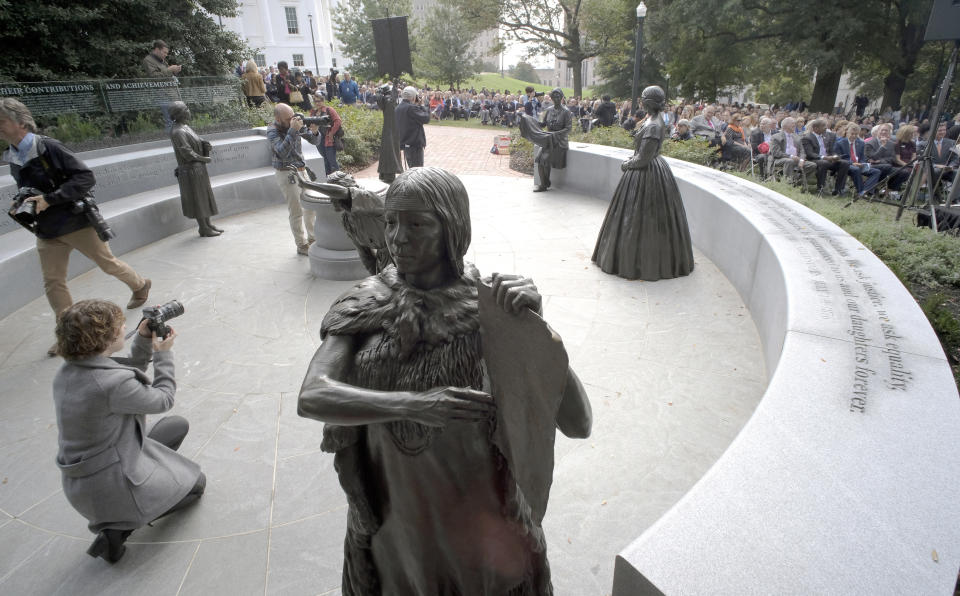 Photographers take pictures of the statues unveiled as the crowd listens to speakers at the dedication of the Virginia Women's Monument inside Capitol Square in Richmond, Va., Monday, Oct. 14, 2019. A total of seven statues of Virginia women were unveiled. (Bob Brown/Richmond Times-Dispatch via AP)