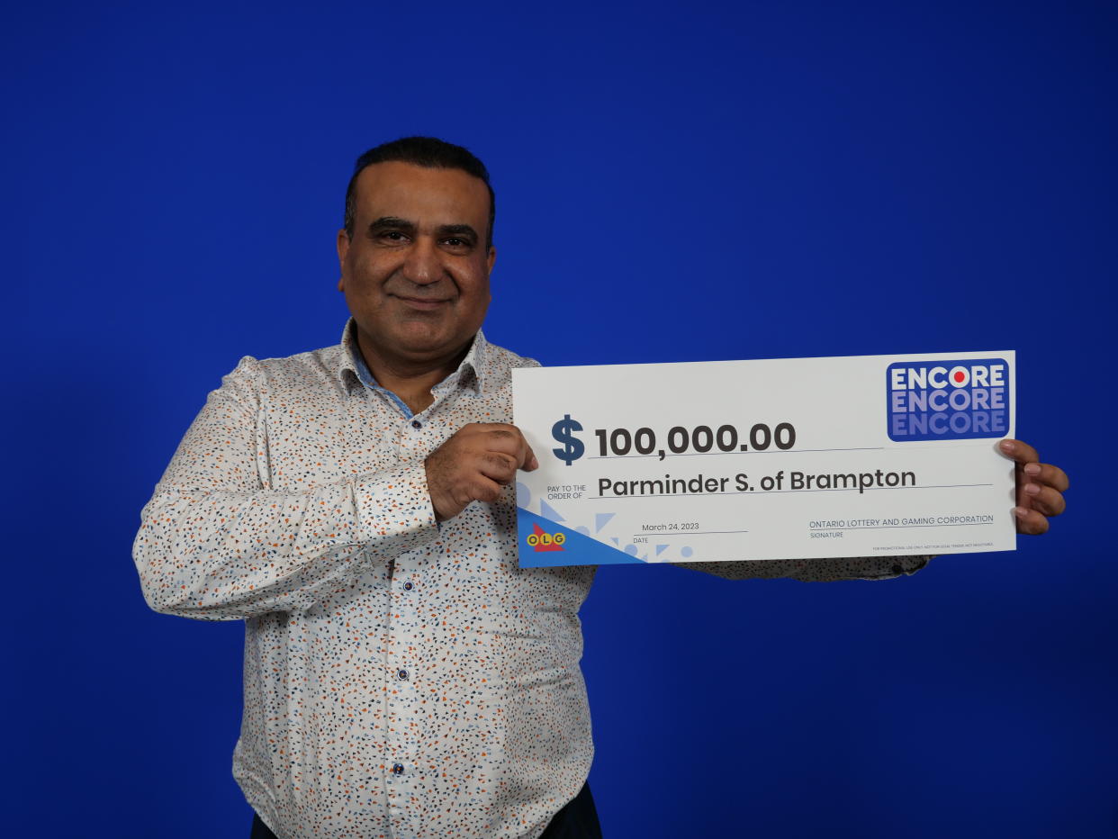 Brampton man holds a $100,000 cheque from OLG. 