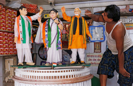 A confectioner decorates a model, made out of sweets, depicting Prime Minister Narendra Modi, Chief Minister of West Bengal state Mamata Banerjee and main opposition Congress party Chief Rahul Gandhi, at a sweets shop in Howrah on the outskirts of Kolkata, India, April 29, 2019. REUTERS/Rupak De Chowdhuri