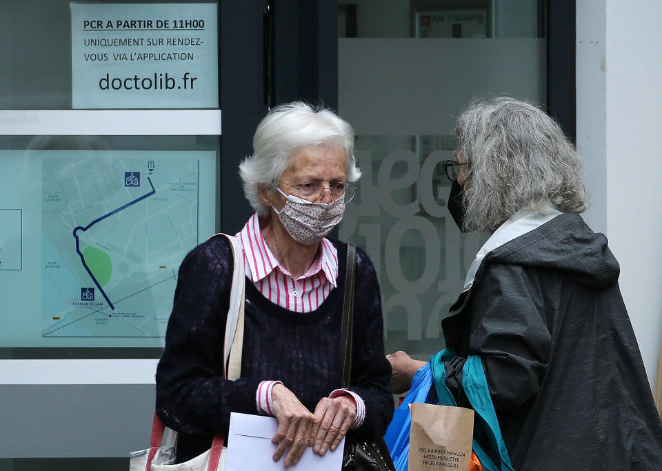 People wearing face mask walk on street in Saint Jean de Luz, southwestern France, Monday, June 20, 2022. Tourism is on the rebound around the world this summer after two years of pandemic restrictions, with museums and flights packed – but the global recovery is hampered by inflation and rising virus infection rates in many regions. (AP Photo/Bob Edme)