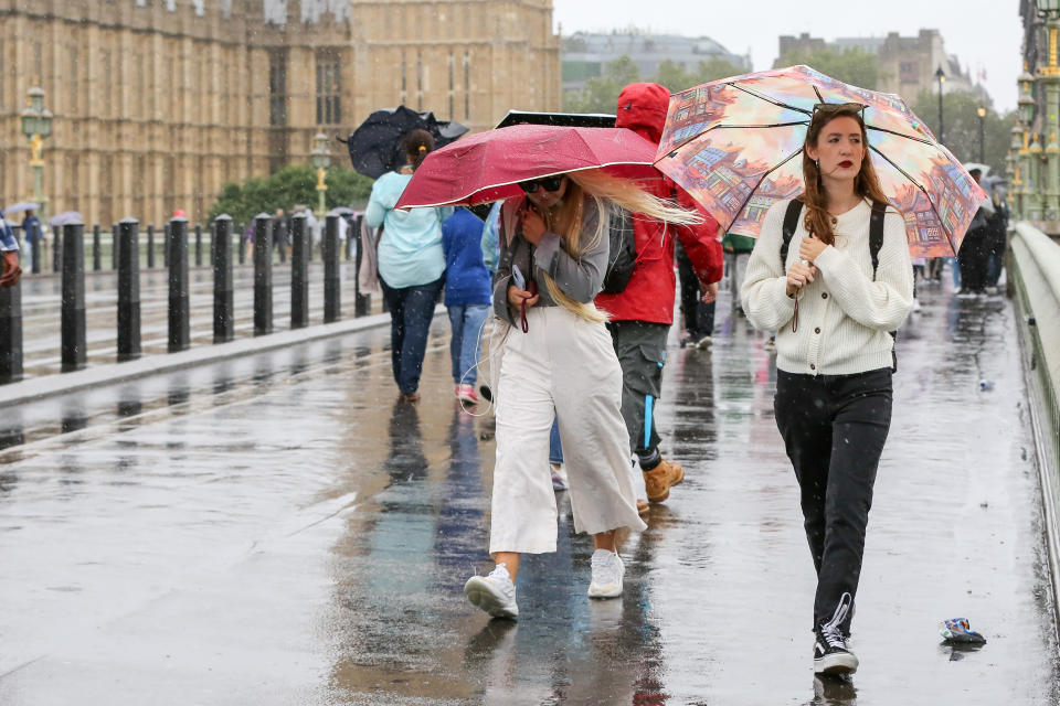 LONDON, UNITED KINGDOM - 2023/08/02: Women shelter under umbrellas in the rain in London. Weather forecasters are predicting more for the rest of the week. (Photo by Steve Taylor/SOPA Images/LightRocket via Getty Images)