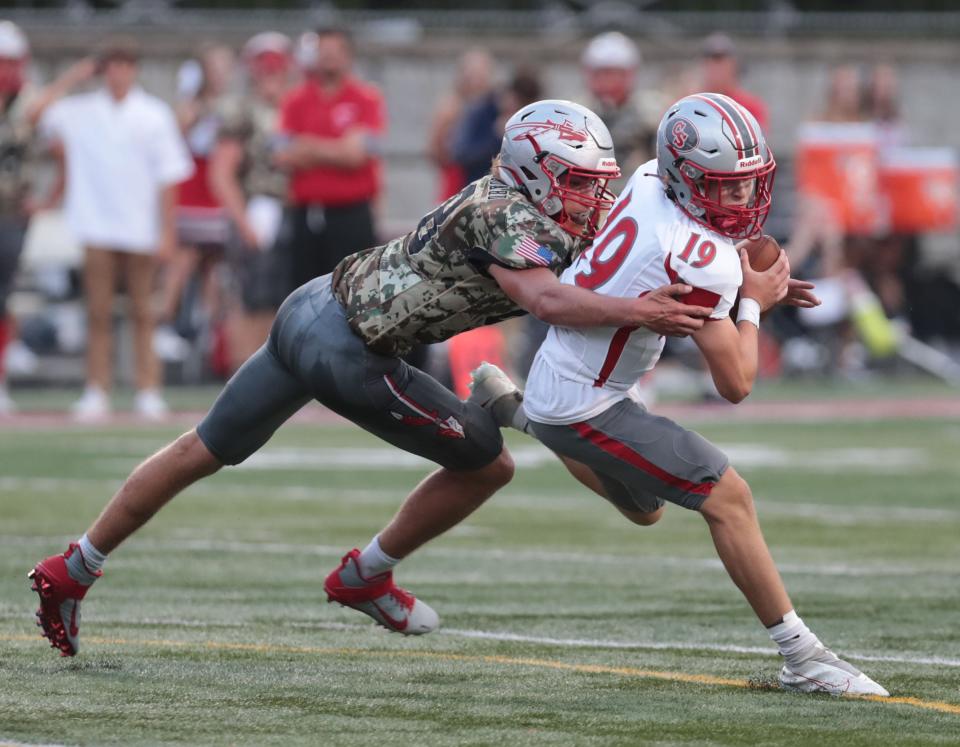 Canton South quarterback Poochie Snyder tries to elude a Northwest defender, Friday, September 3, 2021.