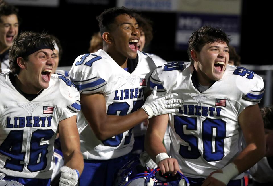 Olentangy Liberty's Jack Kendall (46), Kaleb Shumate (37) and Landon Hunter (50) celebrate after a 14-3 win over Perrysburg in an OHSAA Division I Semifinal game Nov. 11 in Fostoria.