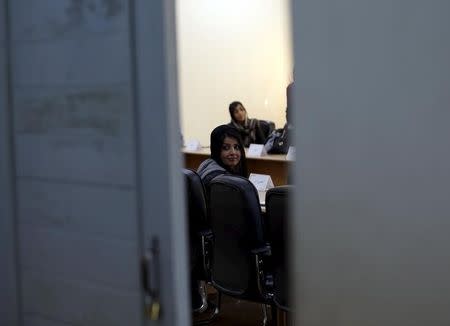 An Afghan woman looks on as she attends a class of the gender and women's studies masters program in Kabul University, Afghanistan October 19, 2015. REUTERS/Mohammad Ismail