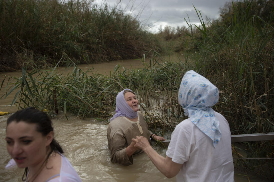 Christian pilgrims stand in the waters of the Jordan River during a baptism ceremony as part of the Orthodox Feast of the Epiphany at the Qasr al-Yahud baptismal site, near the West Bank town of Jericho, on Friday, Jan. 19, 2018. Tourists and pilgrims come to the river from near and far, many driven by faith, to follow in Christ’s footsteps, to touch its water, to conjure up biblical events. (AP Photo/Oded Balilty)