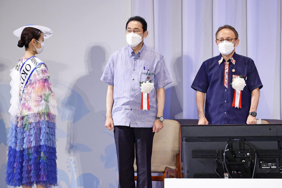 Japan's Prime Minister Fumio Kishida, center, and Okinawa Gov. Denny Tamaki, right, attend a ceremony to mark the 50th anniversary of Okinawa's return to Japan after 27 years of American rule, in Ginowan, Okinawa prefecture, Japan Sunday, May 15, 2022. The ceremonies are held in Tokyo and Okinawa simultaneously. (Kyodo News via AP)