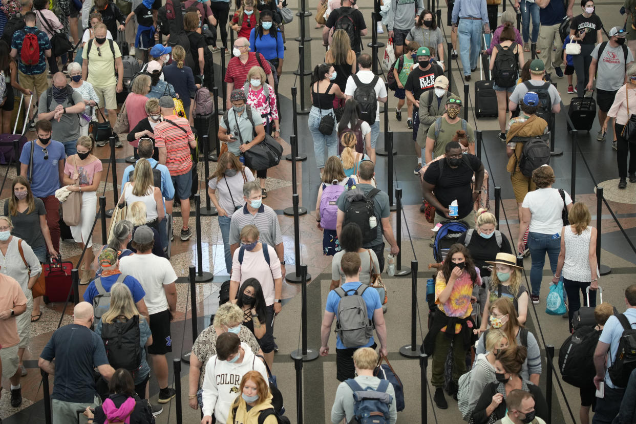 Travelers queue up in long lines to pass through the south security checkpoint in Denver International Airport, Wednesday morning, June 16, 2021, in Denver. (AP Photo/David Zalubowski)