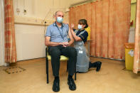 Professor Andrew Pollard, Director of the Oxford Vaccine Group, and a professor of paediatric infection and immunity receives the Oxford University/AstraZeneca COVID-19 vaccine from nurse Sam Foster at the Churchill Hospital in Oxford, England, Monday, Jan. 4, 2021. England’s National Health Service says a retired maintenance manager has received the first injection of the new vaccine developed by Oxford University and drug giant AstraZeneca. Dialysis patient Brian Pinker became the very first person to be vaccinated by the chief nurse at Oxford University Hospital. (Steve Parsons/Pool Photo via AP)