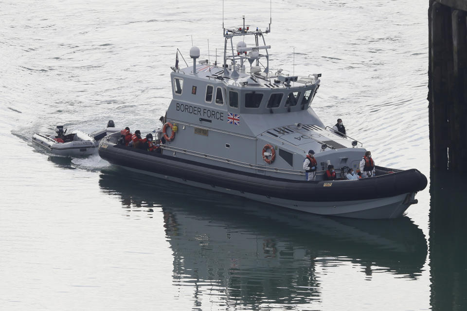 A Border Force vessel brings a group of people thought to be migrants into the port city of Dover, England, from small boats, Saturday Aug. 8, 2020. The British government says it will strengthen border measures as calm summer weather has prompted a record number of people to attempt the risky sea crossing in small vessels, from northern France to England. (AP Photo/Kirsty Wigglesworth)