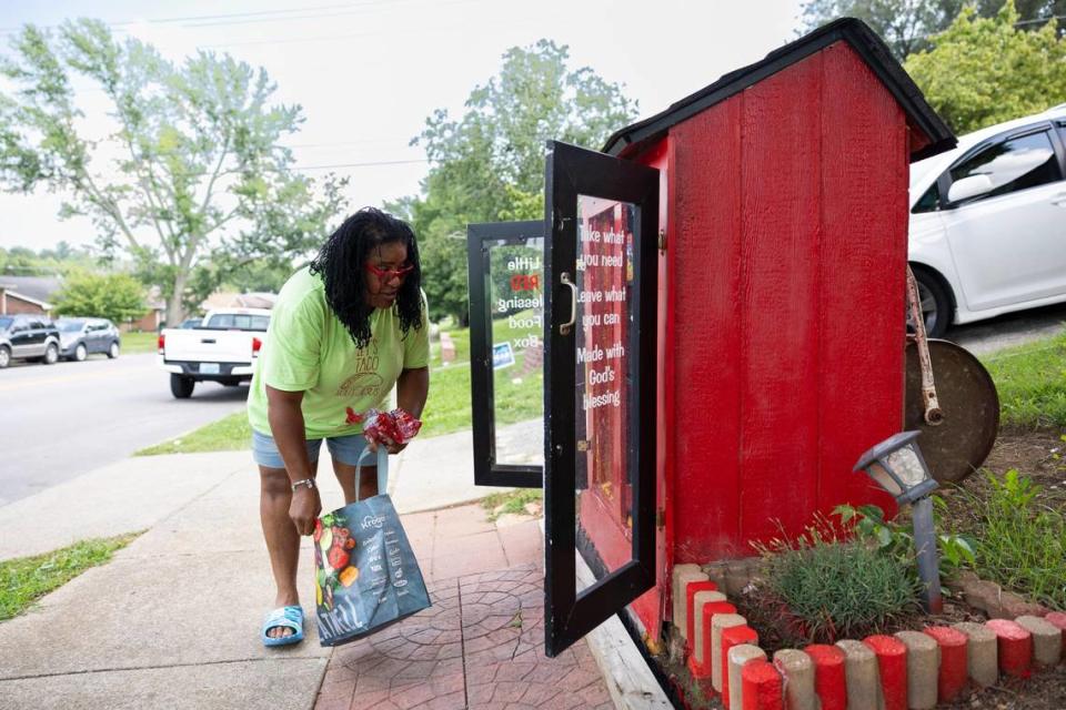 Cynthia Buckner refills her charitable Little Red Blessing Food Box with essentials in front of her house in Lexington, Ky., Friday, July 28, 2023.