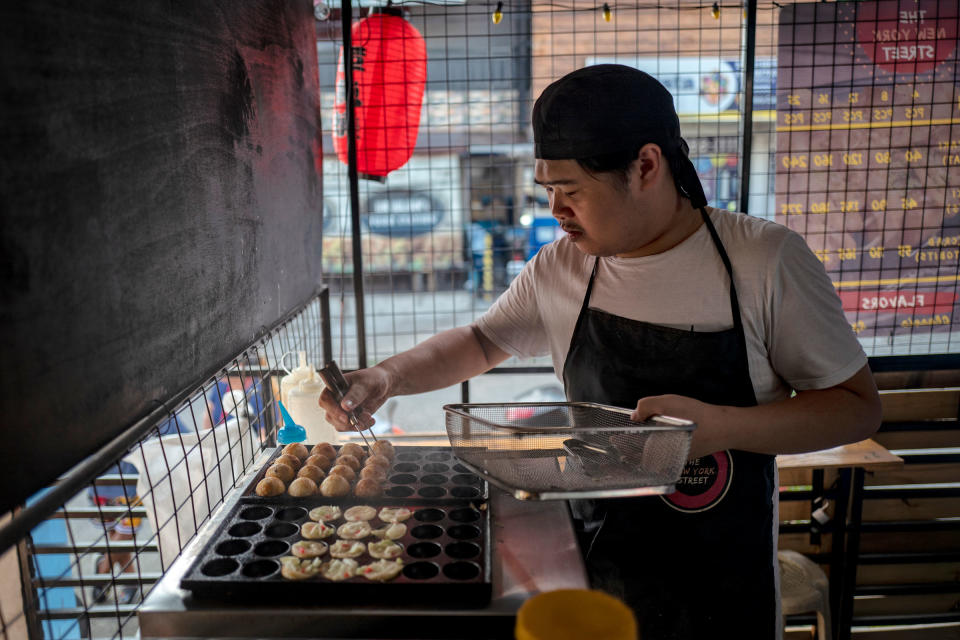 Orias cooks at a Takoyaki shop.<span class="copyright">Ezra Acayan for TIME</span>