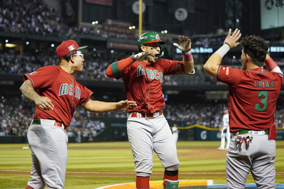 Mexico's Joey Meneses, center, celebrates with teammates after hitting a three-run home run against the United States during the fourth inning of a World Baseball Classic game in Phoenix, Sunday, March 12, 2023. (AP Photo/Godofredo A. Vásquez)